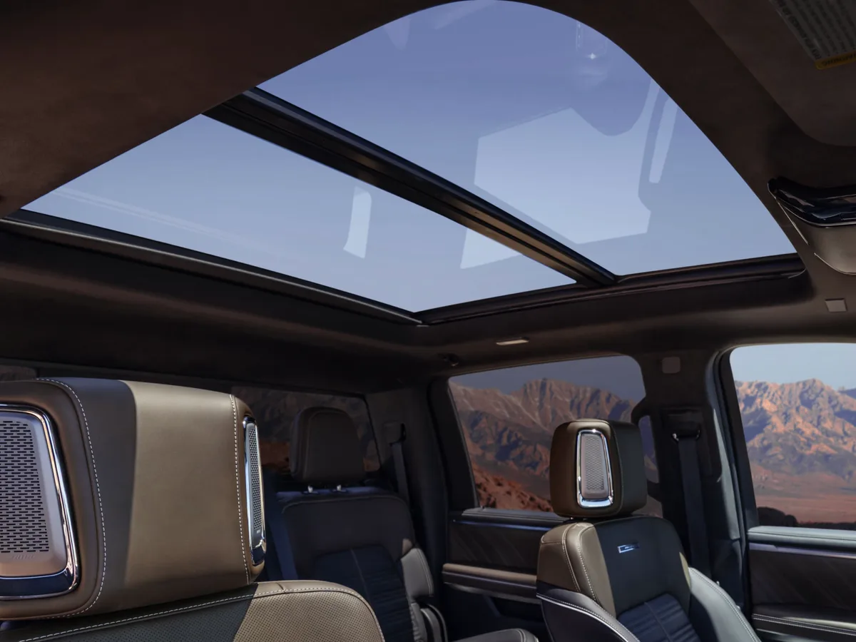 Interior View of the 2027 GMC Sierra 1500 with Brown and Black Seats and a Mountainous Background