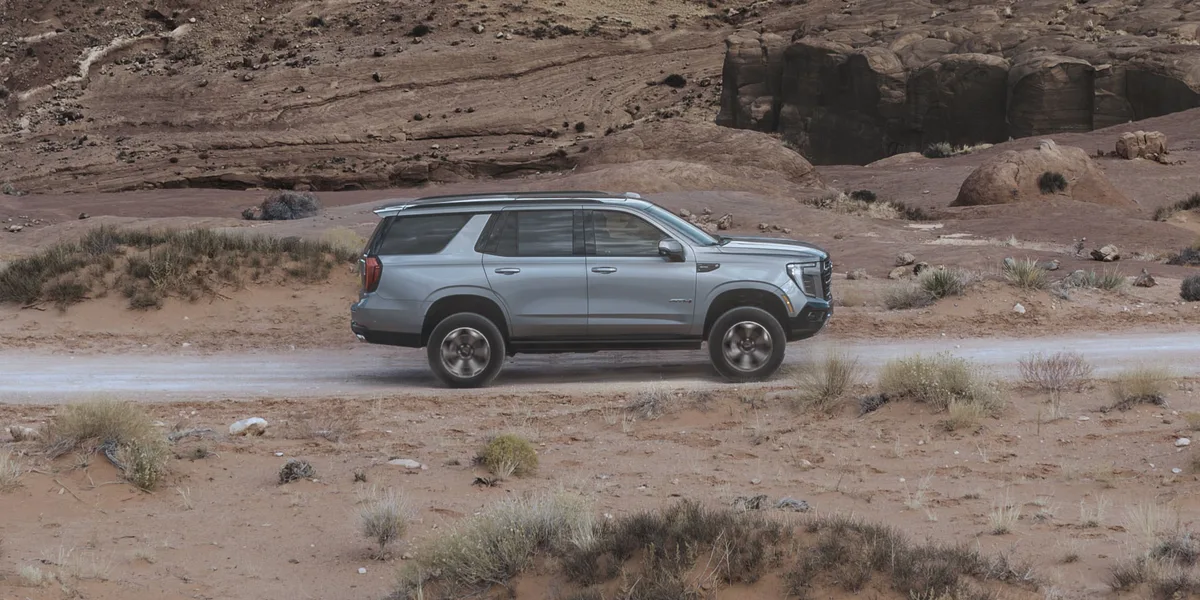 A Gray GMC Yukon AT4 Driving on a Dirt Road in a Desert Landscape