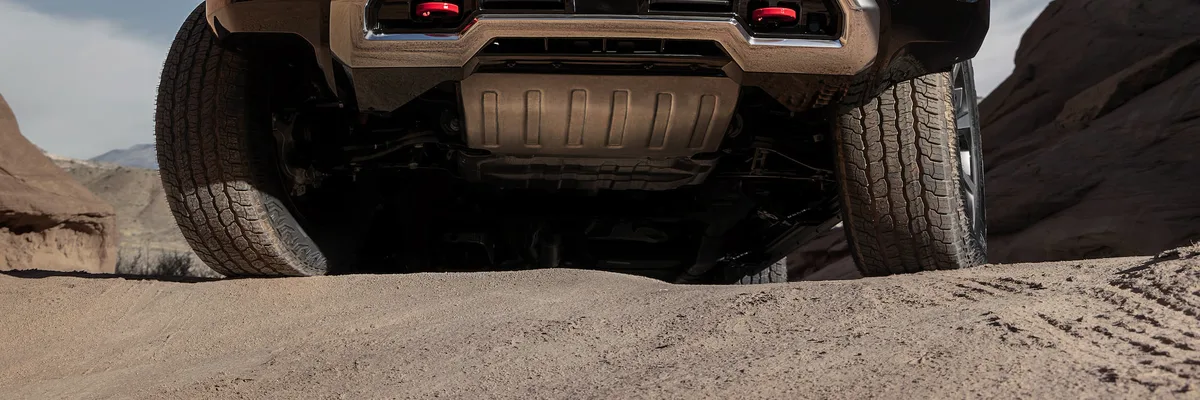 An Extreme Low-Angle View of a GMC Yukon AT4 with its Undercarriage and Red Recovery Hooks